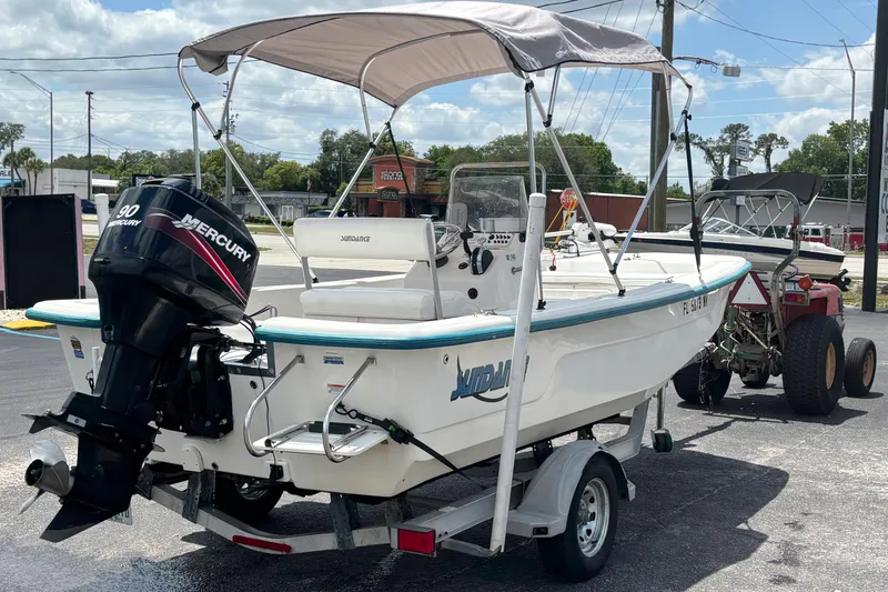 Slide: The Image of 2008 Sundance B18CC boat with Mercury 90 engine on trailer, parked outdoors. - 4