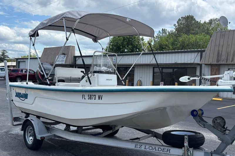 Slide: The Image of 2008 Sundance B18CC boat on trailer with canopy, parked outside a sales building. - 6