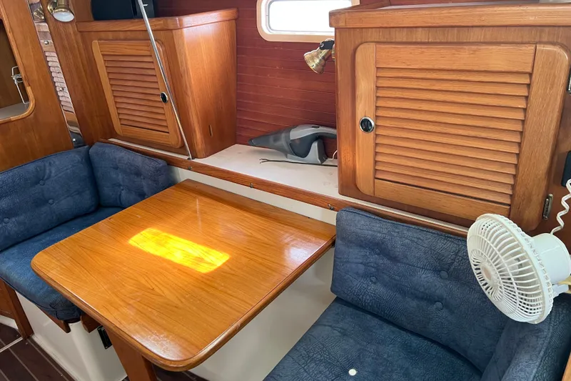 Slide: The Image of Interior of 1999 Catalina 36 MkII sailboat with wooden table and blue cushioned seating. - 7