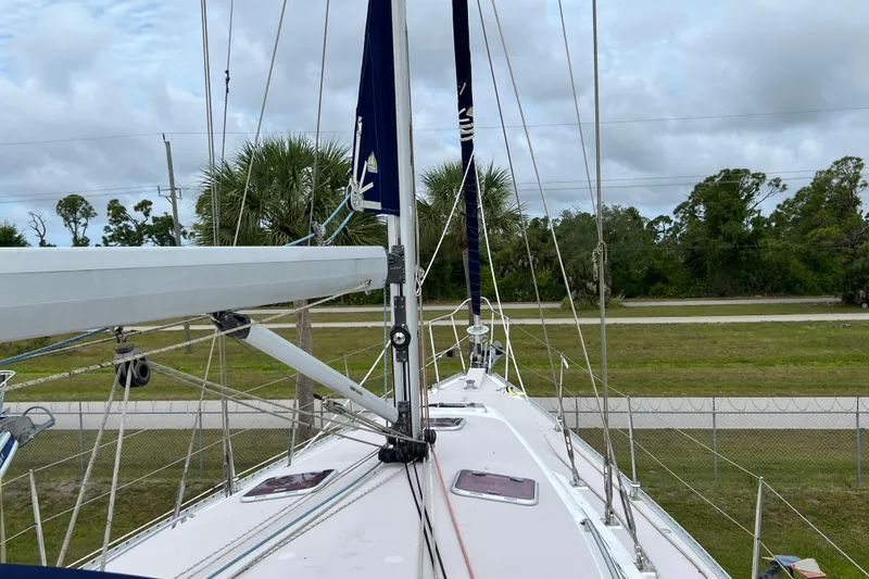Slide: The Image of Catalina 470 sailboat deck view, 2008 model, with rigging and lush greenery background. - 15