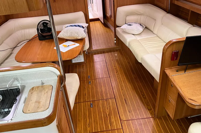 Slide: The Image of Interior of 2008 Catalina 470 yacht with wooden flooring and comfortable seating area. - 16