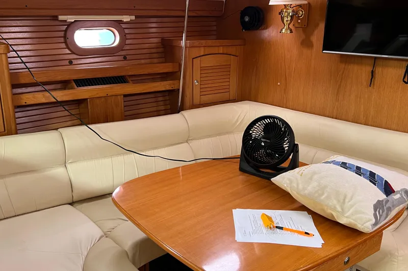Slide: The Image of Interior of 2008 Catalina 470 yacht with beige seating, table, fan, and pillow. - 18