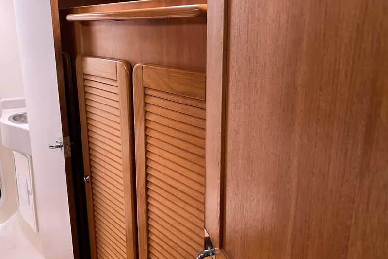 Slide: The Image of Wooden interior of 2008 Catalina 470 yacht, featuring louvered doors and a compact sink area. - 24