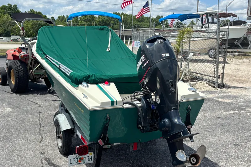 Slide: The Image of 1966 Mohawk 15 boat with green cover and Evinrude motor, parked on trailer. - 10