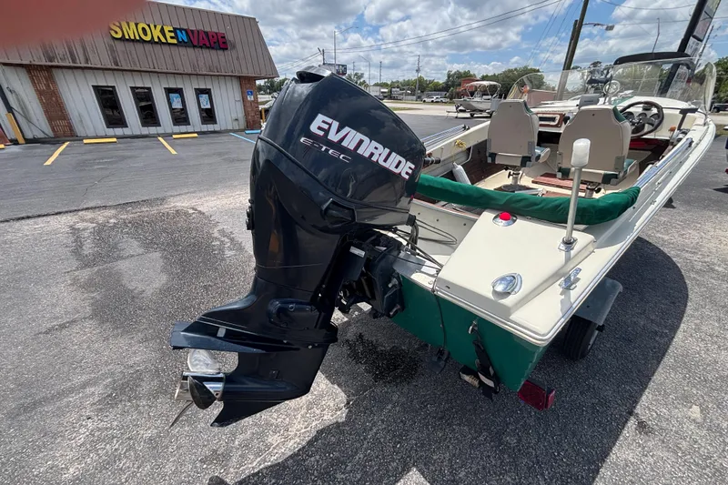 Slide: The Image of 1966 Mohawk 15 boat with Evinrude motor parked near Smoke N Vape shop. - 17