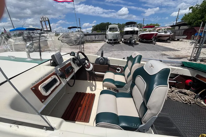Slide: The Image of 1966 Mohawk 15 boat interior with vintage dashboard and dual-tone seating at a marina. - 22