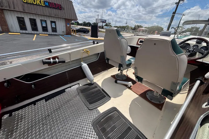 Slide: The Image of Interior of a 1966 Mohawk 15 boat with two seats, parked near a store. - 29