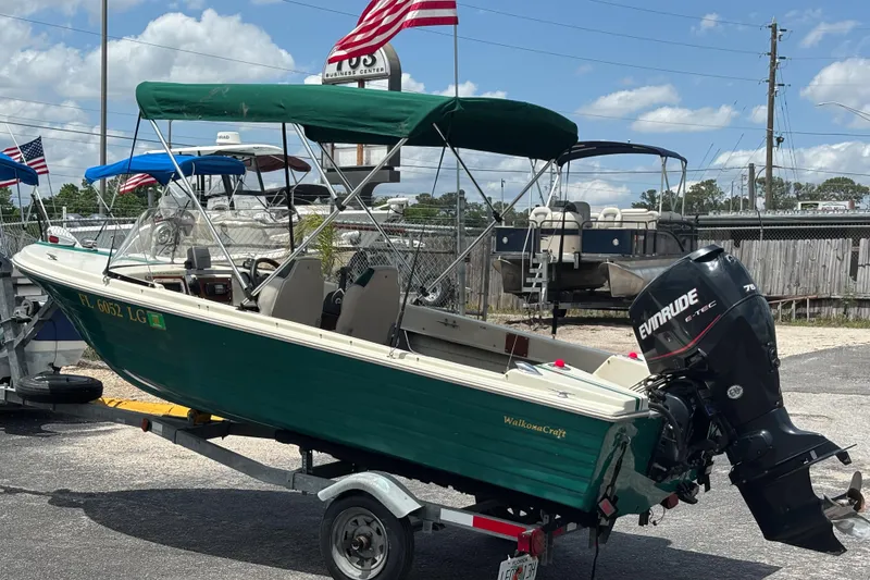 Slide: The Image of 1966 Mohawk 15 boat with Evinrude motor on trailer, parked outdoors under blue sky. - 3