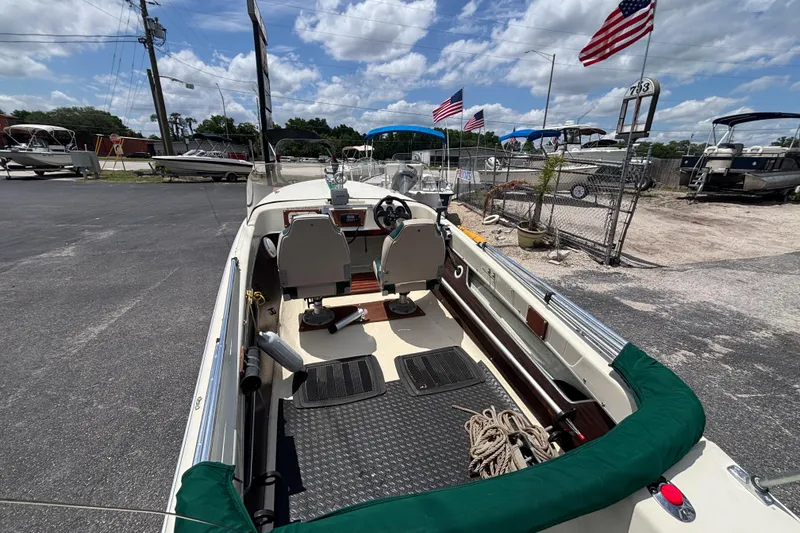 Slide: The Image of 1966 Mohawk 15 boat interior with steering wheel, seats, and American flags in the background. - 30