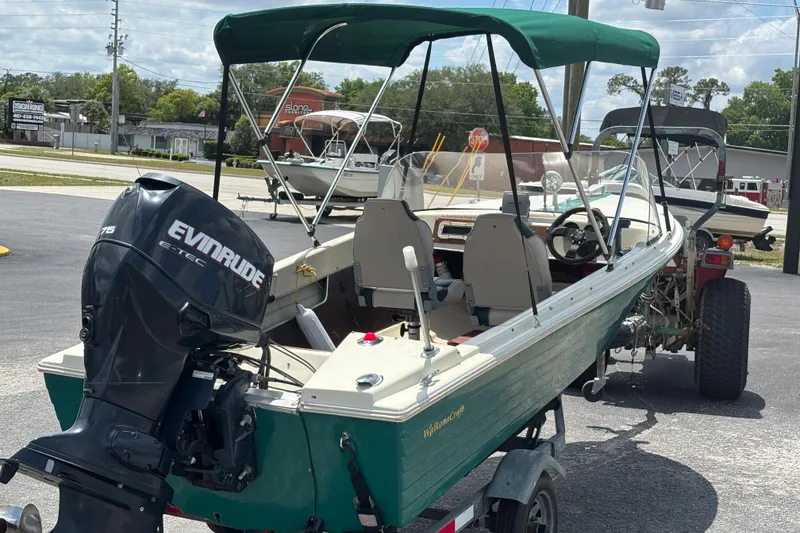 Slide: The Image of 1966 Mohawk 15 boat with Evinrude motor, parked on a trailer in a lot. - 6
