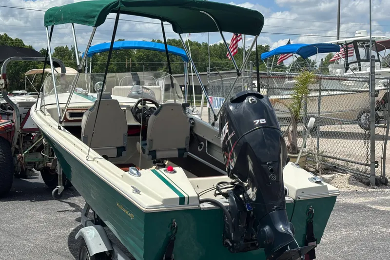 Slide: The Image of 1966 Mohawk 15 boat with canopy and outboard motor in a marina setting. - 9