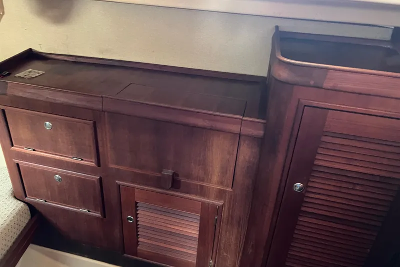 Slide: The Image of 2002 Island Packet 380 sailboat, aft berth featuring drawers and a louvered door. - 13