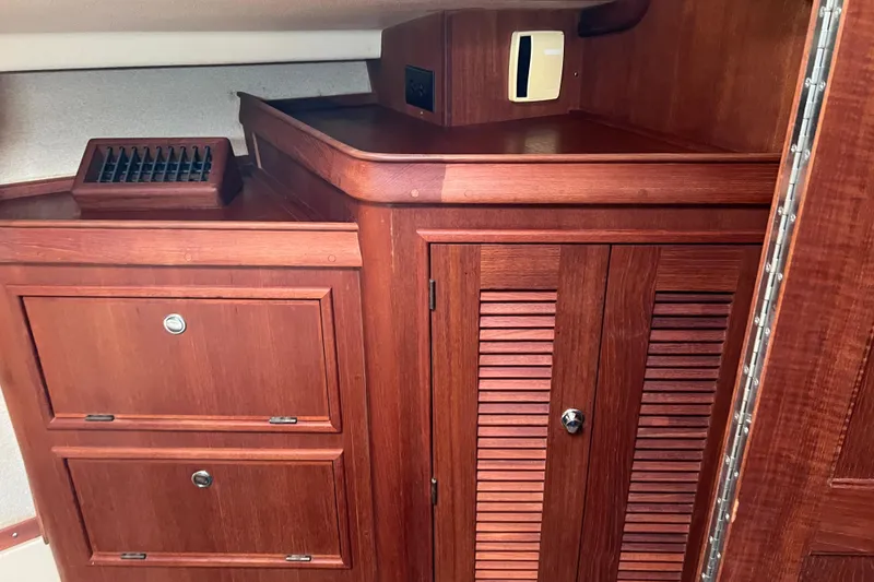 Slide: The Image of Interior cabinetry of the forward stateroom on 2002 Island Packet 380 sailboat, featuring rich wood finish. - 15