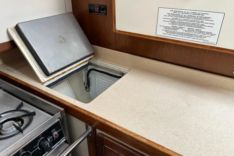 Slide: The Image of Interior of a 1997 Catalina 400 yacht kitchen with stove and open fridge compartment. - 11