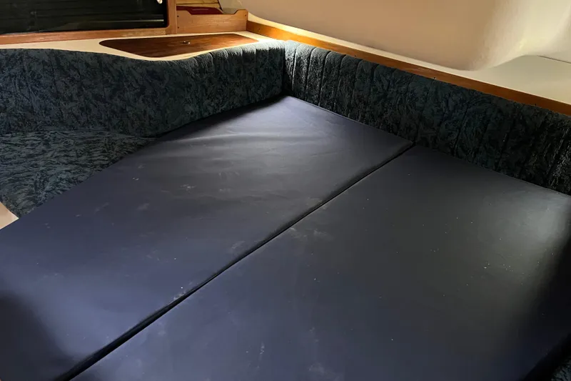 Slide: The Image of Interior seating area of a 1997 Catalina 400 sailboat with dark cushions. - 20