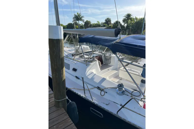 Slide: The Image of Sailboat Catalina 400, 1997 model, docked with blue canopy and tropical background. - 5