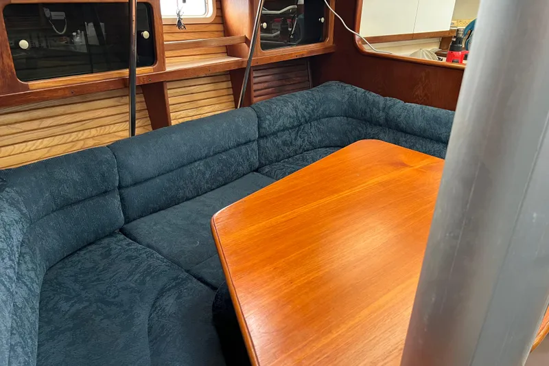 Slide: The Image of Interior of a 1997 Catalina 400 sailboat with a wooden table and cushioned seating. - 9