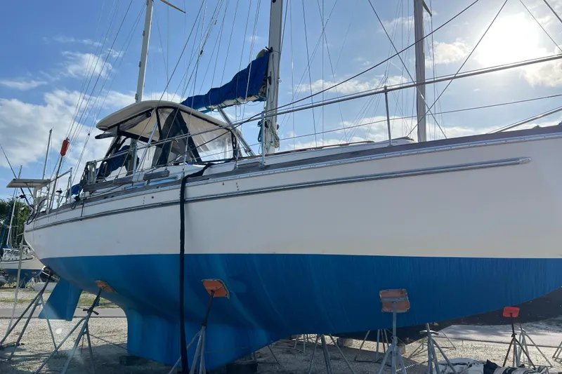 The Image of 1977 Gulfstar 43 sailboat on stands, blue hull, sunny day. - 1