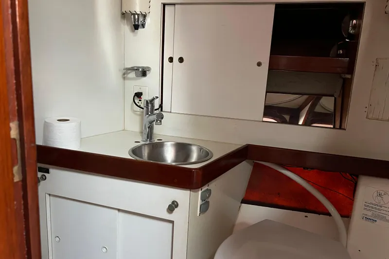 Slide: The Image of 1977 Gulfstar 43 yacht bathroom with sink, mirror, and storage cabinets. - 13