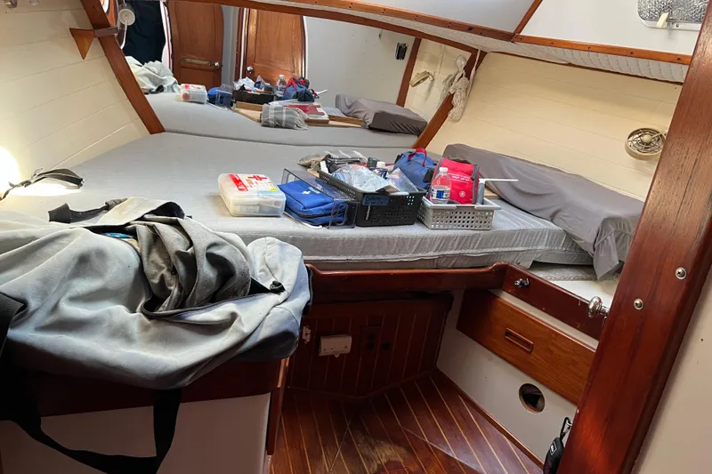 Slide: The Image of Cozy cabin interior of a 1977 Gulfstar 43 sailboat with organized supplies on the bed. - 15