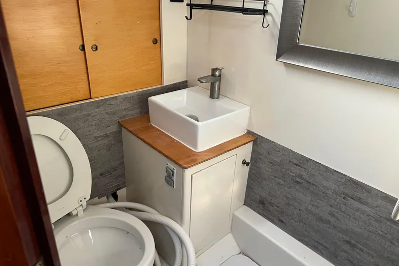 Slide: The Image of 1977 Gulfstar 43 yacht bathroom with modern sink, toilet, and wooden cabinetry. - 16