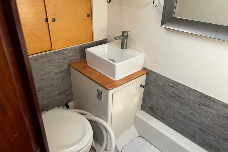 Slide: The Image of 1977 Gulfstar 43 yacht bathroom with modern sink, toilet, and wooden cabinetry. - 17