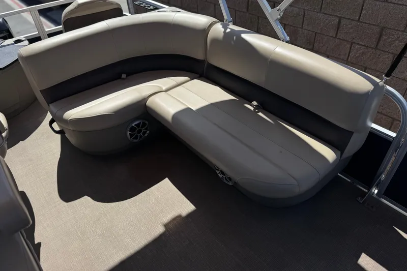 Slide: The Image of 2024 Sun Tracker Bass Buggy 18 DLX pontoon boat seating area with beige upholstery. - 17