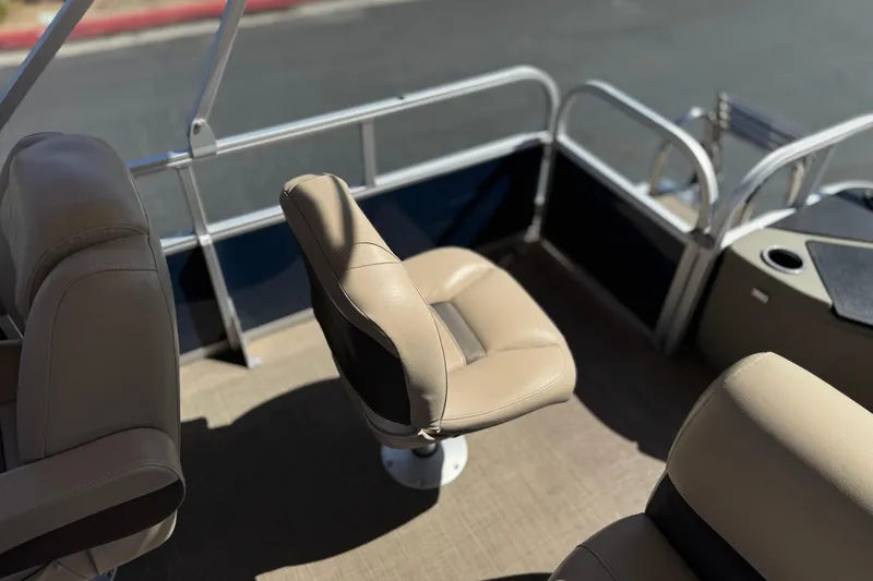 Slide: The Image of 2024 Sun Tracker Bass Buggy 18 DLX interior with beige seating and railing. - 18