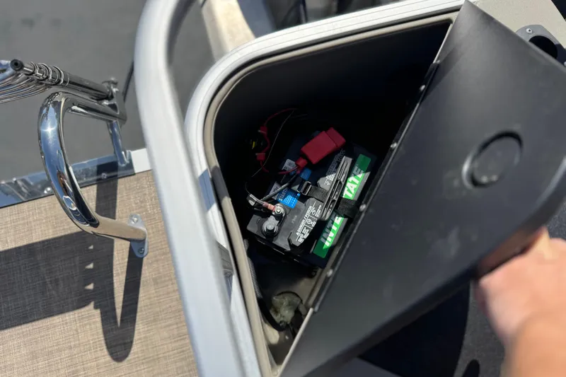 Slide: The Image of 2024 Sun Tracker Bass Buggy 18 DLX battery compartment with visible wiring and components. - 21