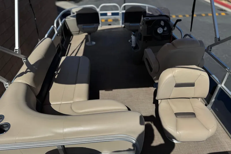 Slide: The Image of 2024 Sun Tracker Bass Buggy 18 DLX interior with beige seating and steering console. - 22