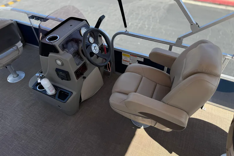 Slide: The Image of 2024 Sun Tracker Bass Buggy 18 DLX boat interior with steering console and captain's chair. - 23