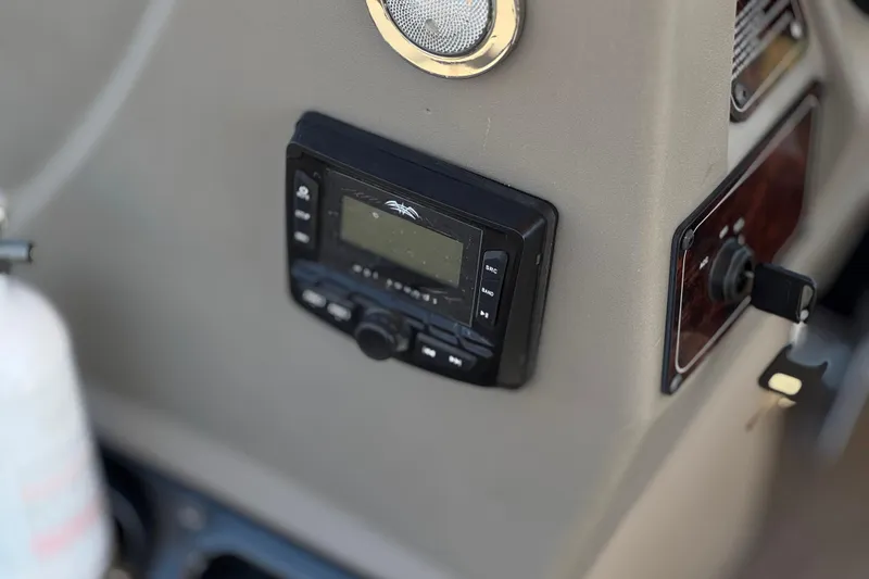 Slide: The Image of 2024 Sun Tracker Bass Buggy 18 DLX dashboard with control panel and speaker. - 25