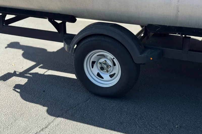 Slide: The Image of Trailer wheel of 2024 Sun Tracker Bass Buggy 18 DLX on pavement. - 28