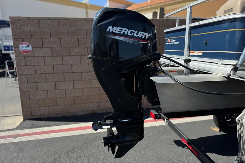 Slide: The Image of 2024 Sun Tracker Bass Buggy 18 DLX with Mercury outboard motor in parking lot. - 7