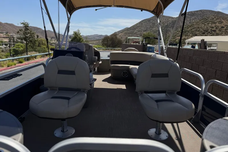 Slide: The Image of 2024 Sun Tracker Bass Buggy 18 DLX pontoon boat interior with seating and canopy. - 9