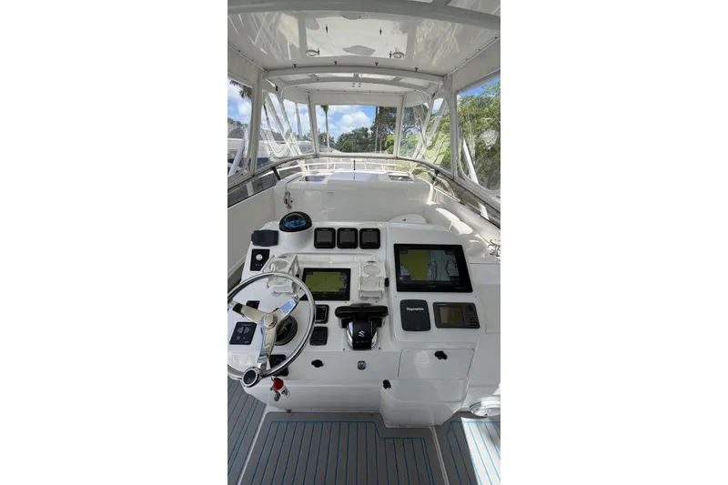 Slide: The Image of 2006 Intrepid 348 Walkaround boat helm with advanced navigation systems and steering wheel. - 11