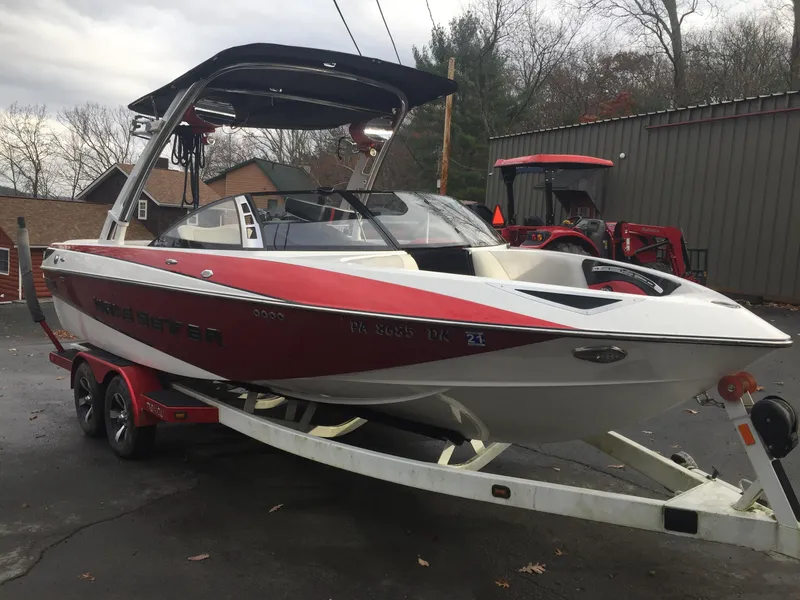 Slide: The Image of 2013 Malibu Wakesetter 23 LSV boat on trailer, red and white. - 2