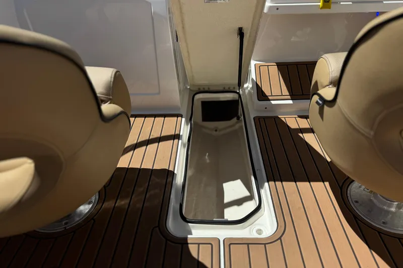 Slide: The Image of 2022 Bayliner VR4 Bowrider I/O interior with open storage compartment and tan seats. - 16