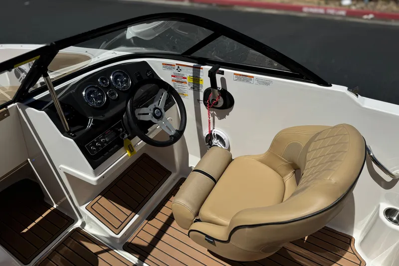 Slide: The Image of 2022 Bayliner VR4 Bowrider I/O cockpit with steering wheel and tan seating. - 20