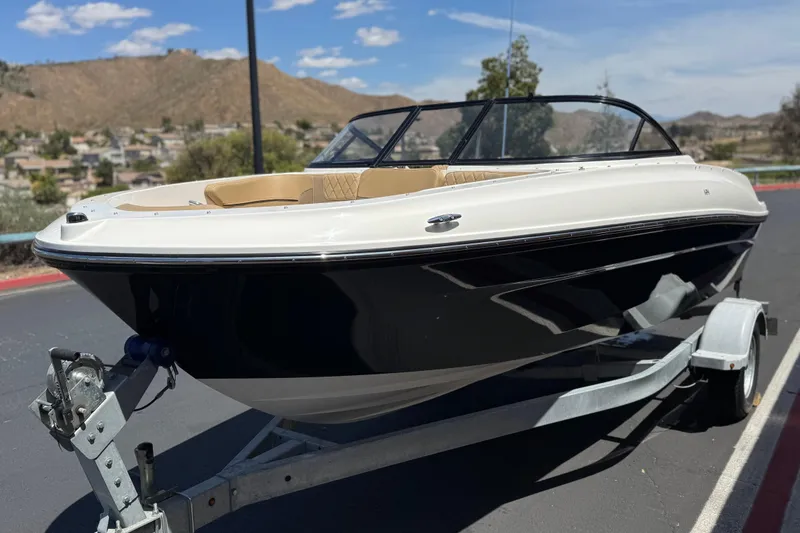 Slide: The Image of 2022 Bayliner VR4 Bowrider I/O on trailer, parked with scenic mountain backdrop. - 3