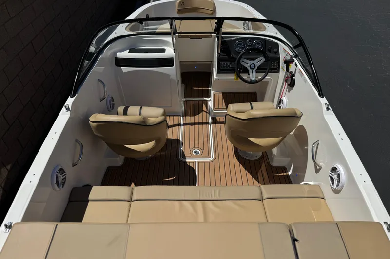 Slide: The Image of 2022 Bayliner VR4 Bowrider I/O interior with tan seating and sleek dashboard design. - 8