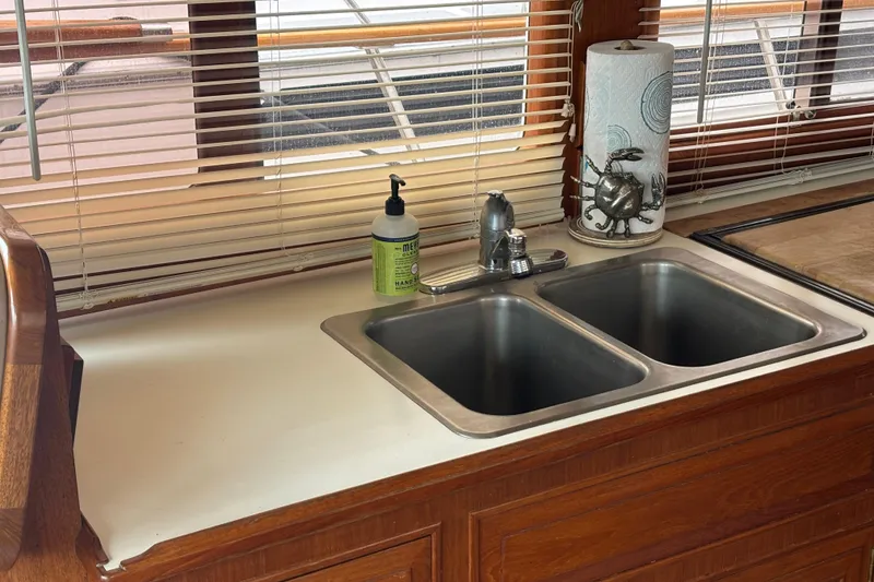 Slide: The Image of Kitchen sink area in 1984 Ocean Alexander 38 Double Cabin yacht with blinds and wooden cabinetry. - 12