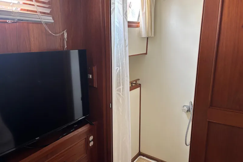 Slide: The Image of 1984 Ocean Alexander 38 Double Cabin interior with TV and shower area. - 20