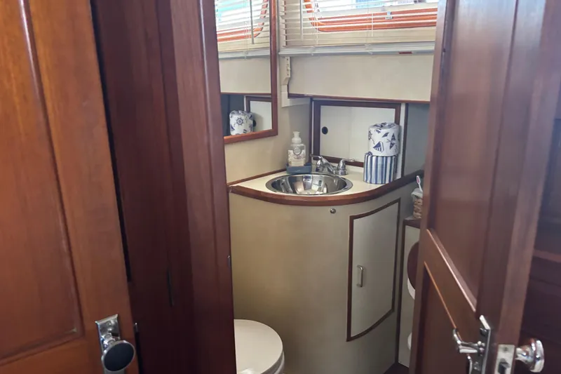 Slide: The Image of 1984 Ocean Alexander 38 Double Cabin bathroom with sink, toilet, and wooden cabinetry. - 21