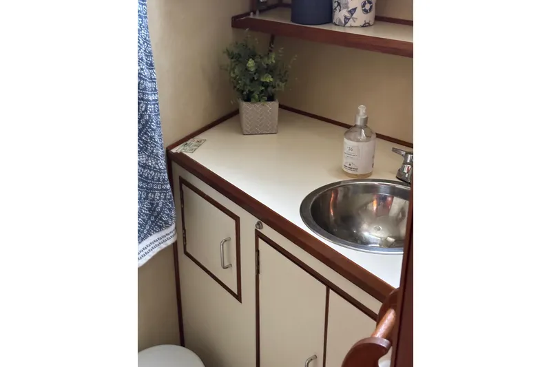 Slide: The Image of 1984 Ocean Alexander 38 Double Cabin bathroom with sink, countertop, and decorative items. - 22