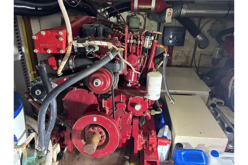 Slide: The Image of Engine room of 1984 Ocean Alexander 38 Double Cabin with red machinery and hoses. - 27