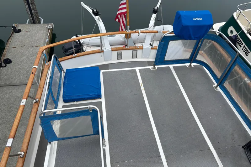 Slide: The Image of 1984 Ocean Alexander 38 Double Cabin deck with blue seating and railing, docked by water. - 5