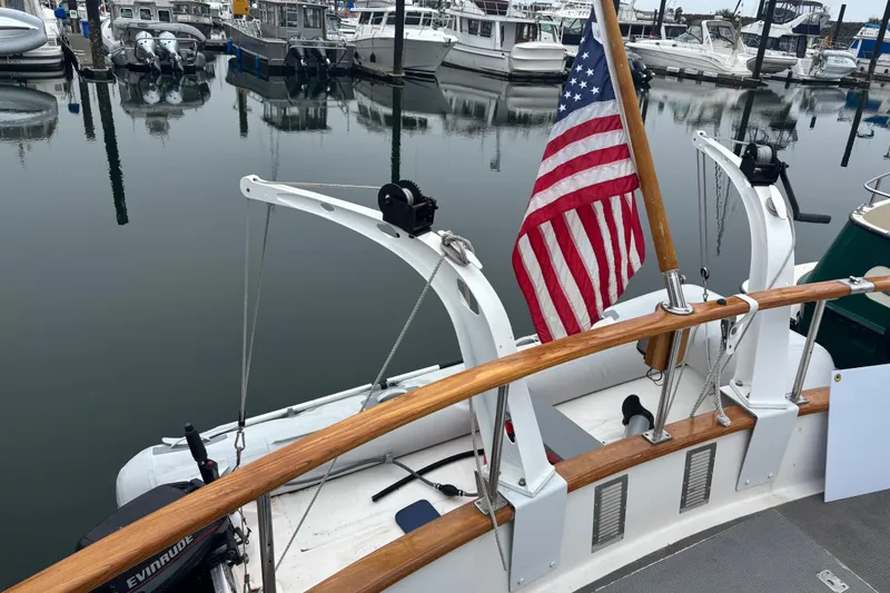 Slide: The Image of 1984 Ocean Alexander 38 Double Cabin at marina with American flag and boats in background. - 6