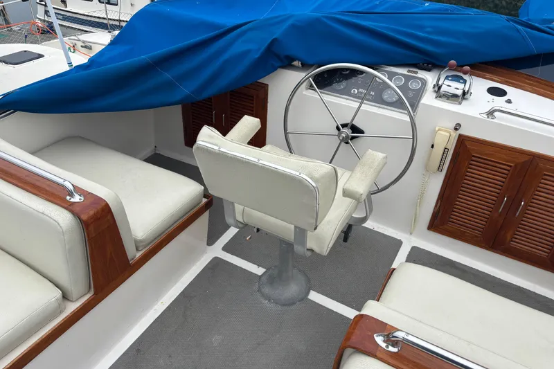 Slide: The Image of Cockpit of 1984 Ocean Alexander 38 Double Cabin with helm, seating, and blue cover. - 8