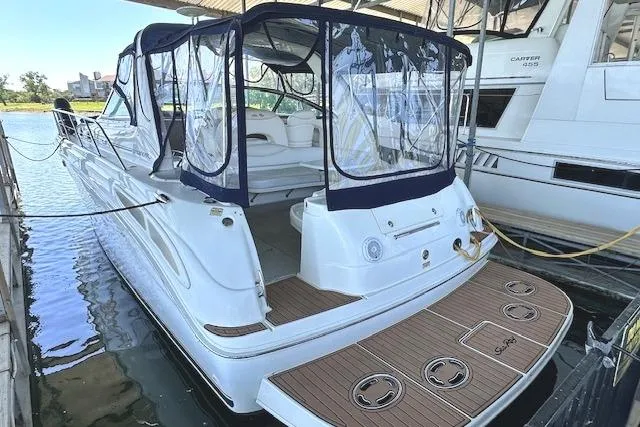 The Image of 2001 Sea Ray 380 Sundancer yacht docked with covered seating area and teak swim platform. - 0